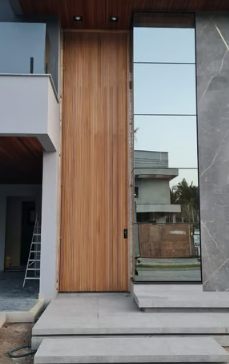 Porta pivotante alta em madeira ripada